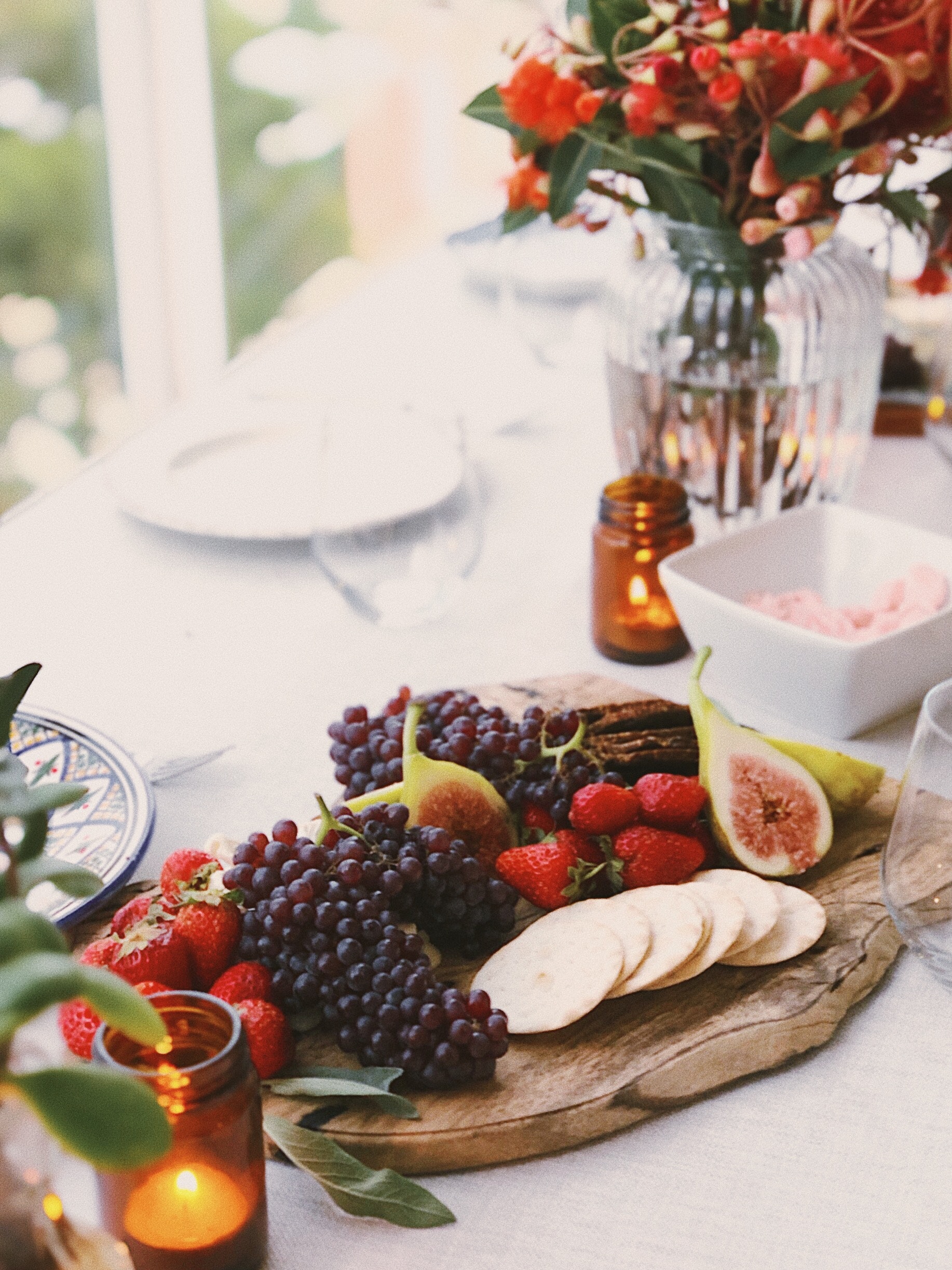 fancy fruit filled charcuterie board on table with a white table cloth.
